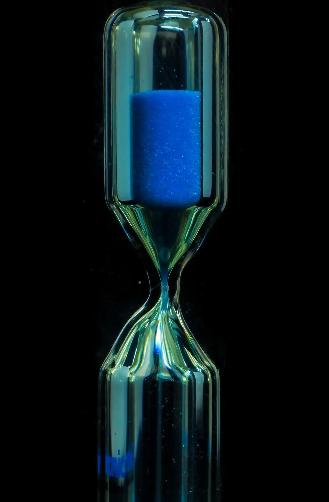 clear glass hour glass with blue liquid